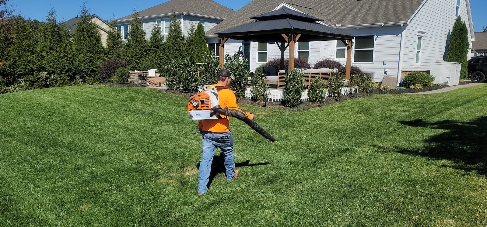 A man in an orange shirt holding a baseball bat